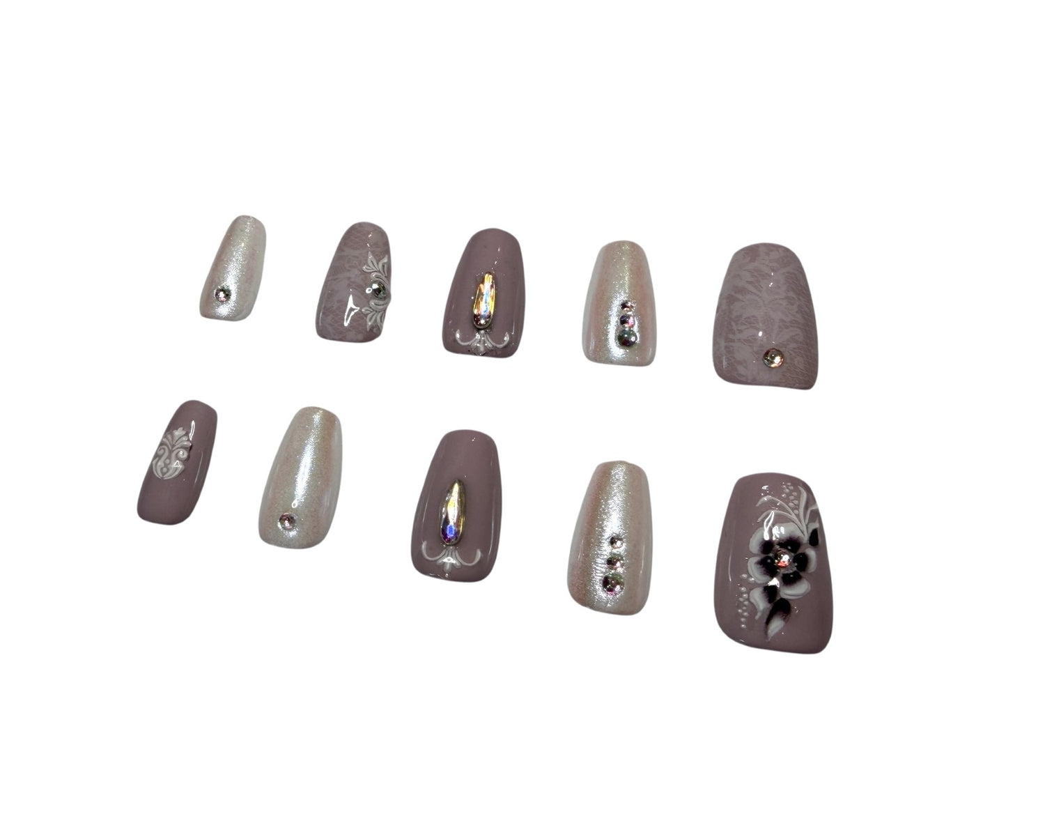 Set of decorative false nails with rhinestones on a white and purple background